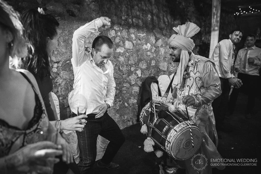 best man dancing to the beat of dhol player at an indian wedding in Ravello