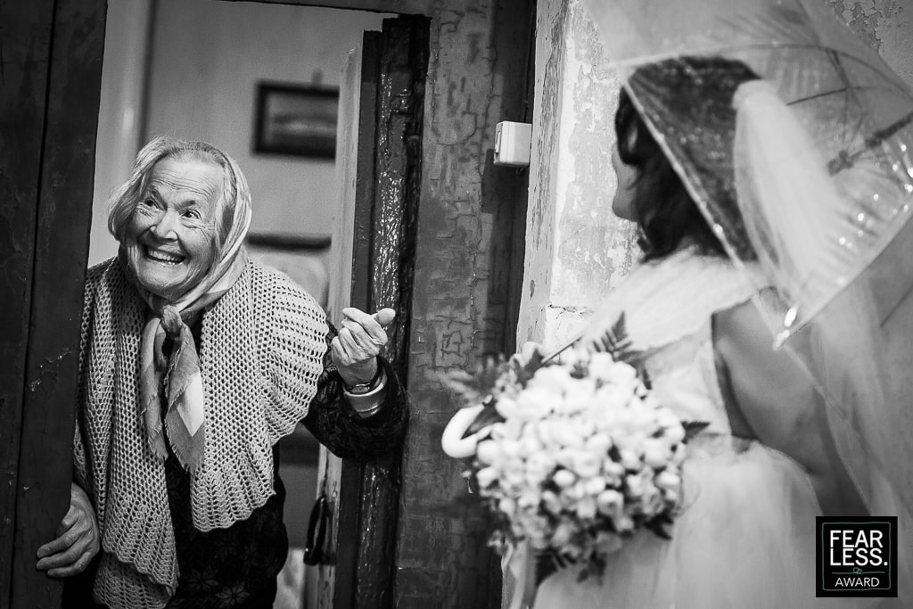 an elderly lady meets the newlyweds at the doorstep of her house on the Amalfi coast