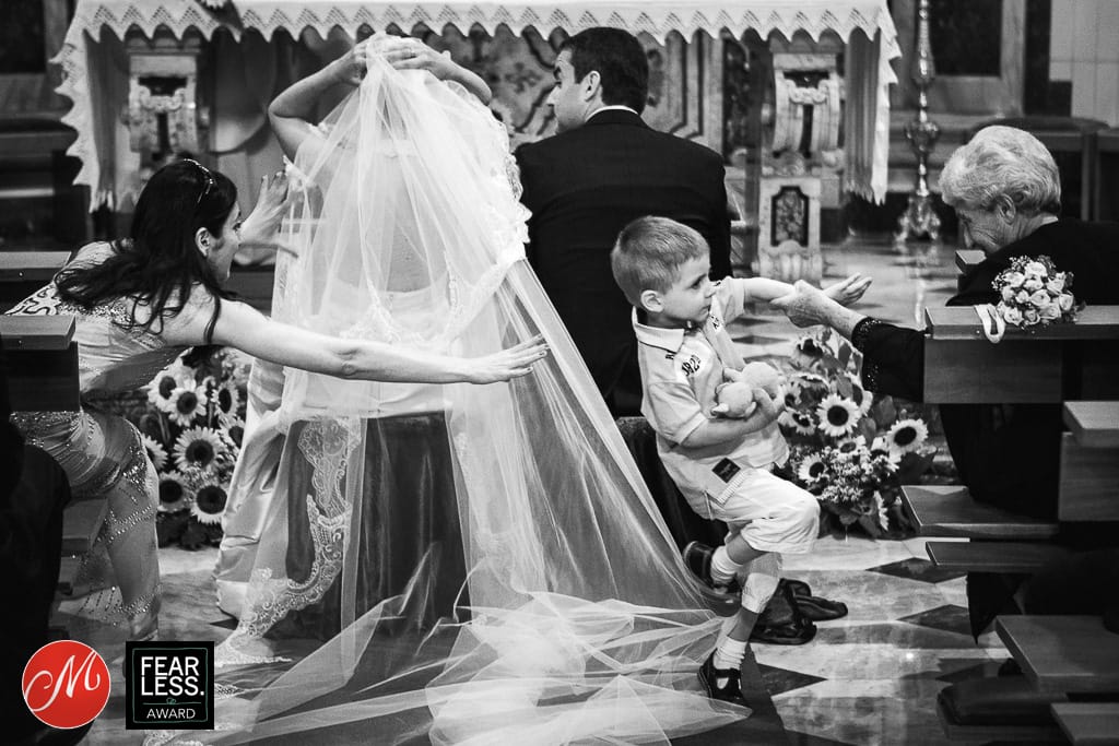 a child stumbles over the bride's veil during a wedding ceremony