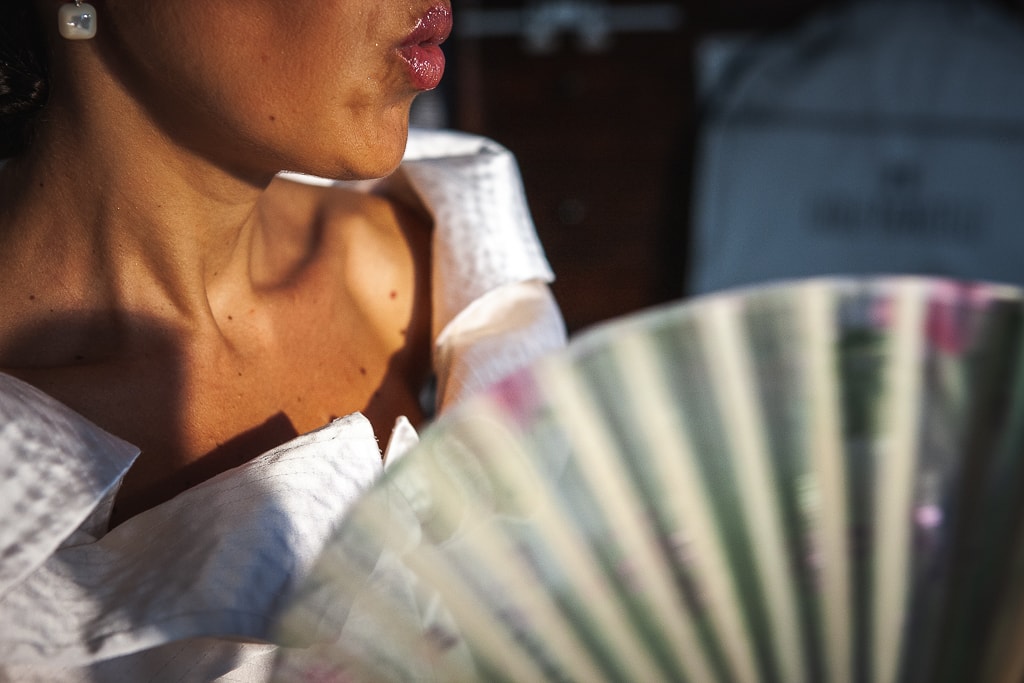 half face of a bride and her folding fan
