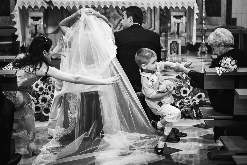 a child stumbles over the bride's veil during a wedding ceremony