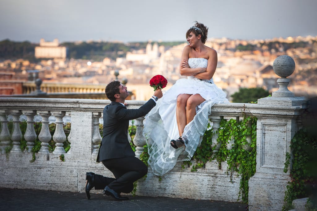 a groom offering the bouquet to the bride on a terrace in rome