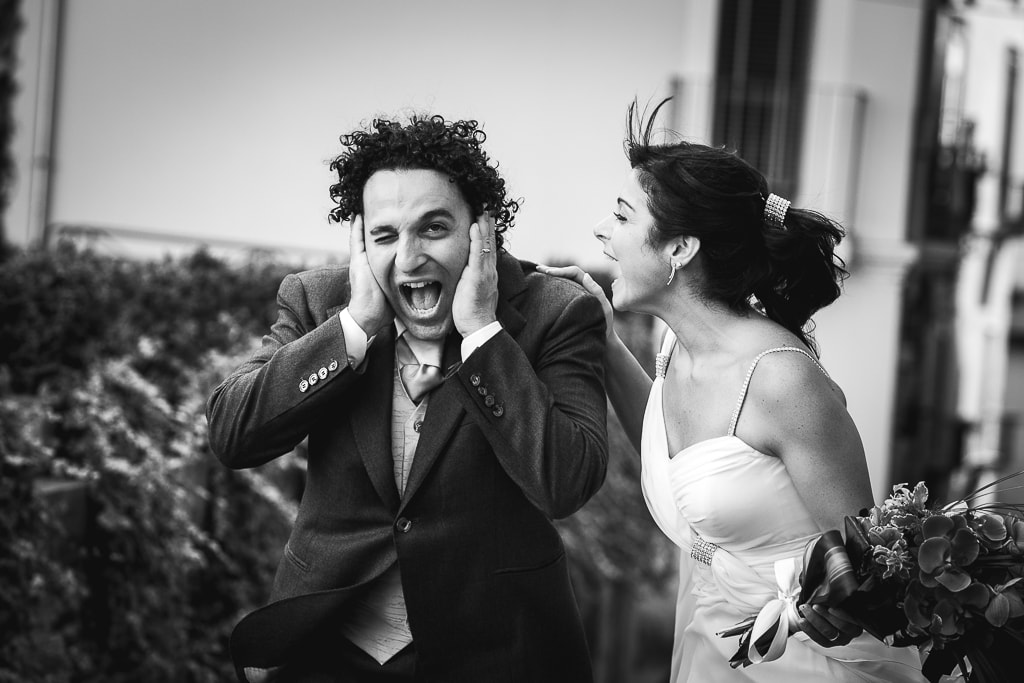 a groom plugs his ears as the bride scolds him