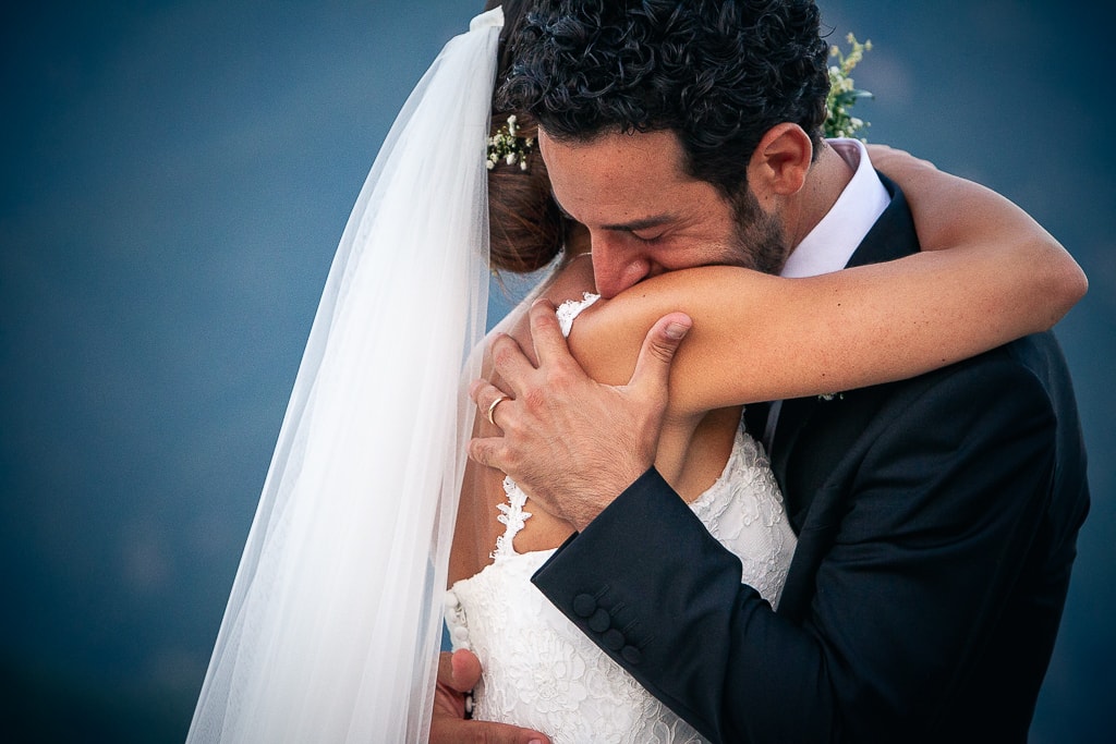 close-up of a wedding couple hugging and a blurred background