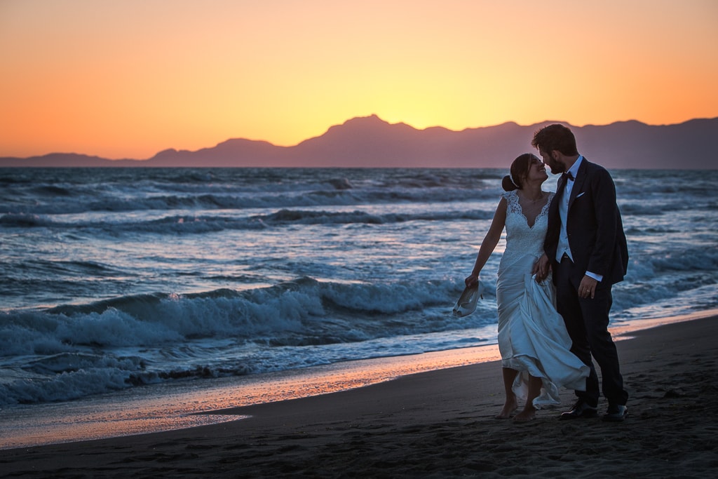 wedding couple walking on the beach at sunset