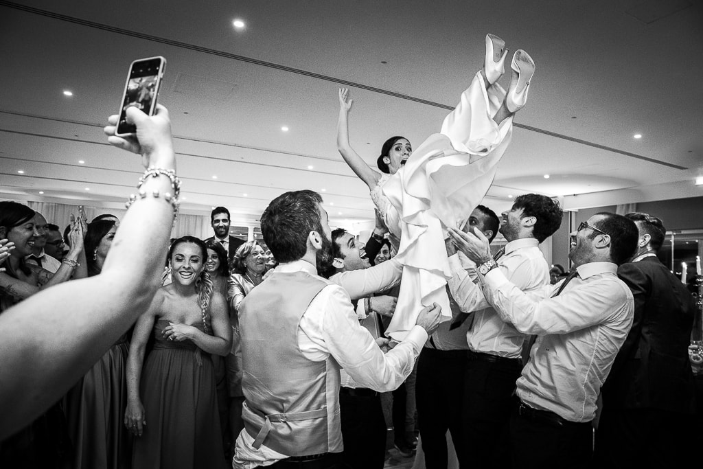guests throwing the bride in the air at a wedding party