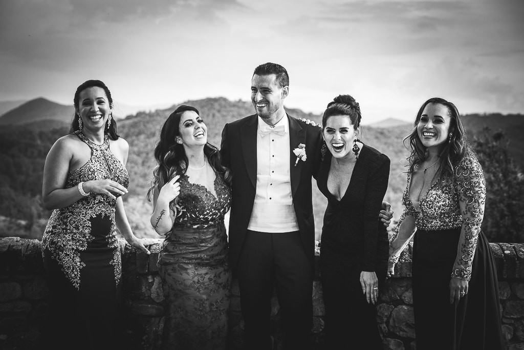 a groom and bridesmaids laughing