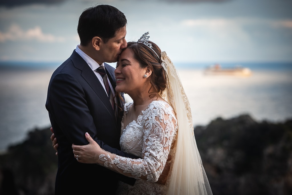 wedding couple hug on a terrace overlooking the sea in amalfi coast