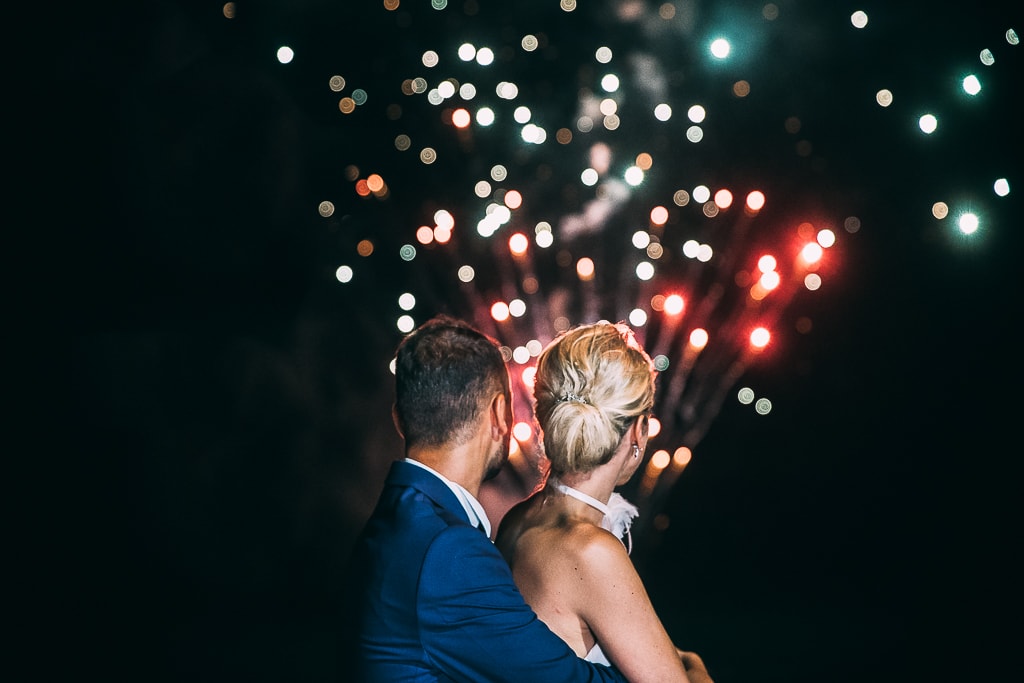 wedding couple from behind and fireworks in the background