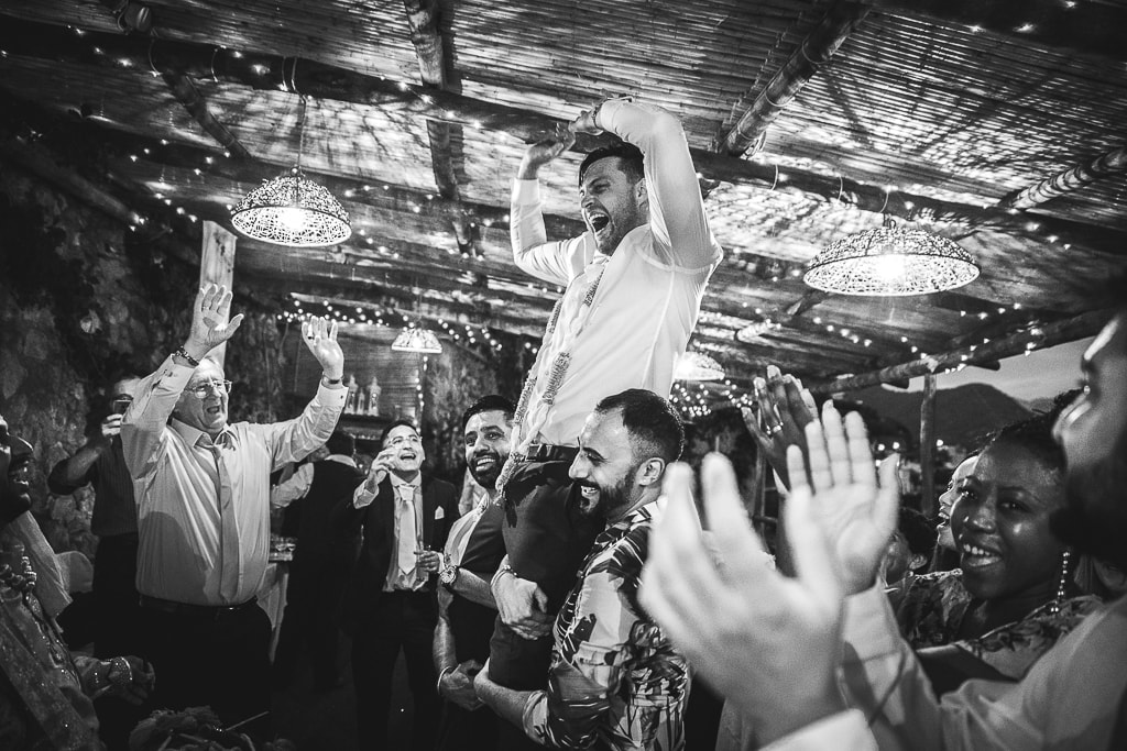 friends of the groom lift him up at a wedding party