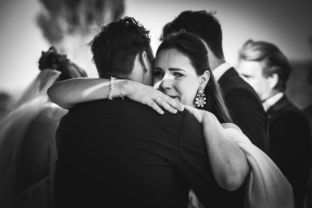 a guest hugs the groom at a wedding in tuscany