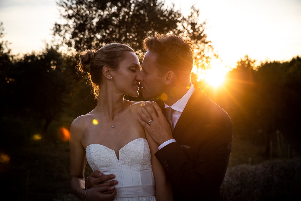 wedding couple kiss against the sunset in tuscany countryside