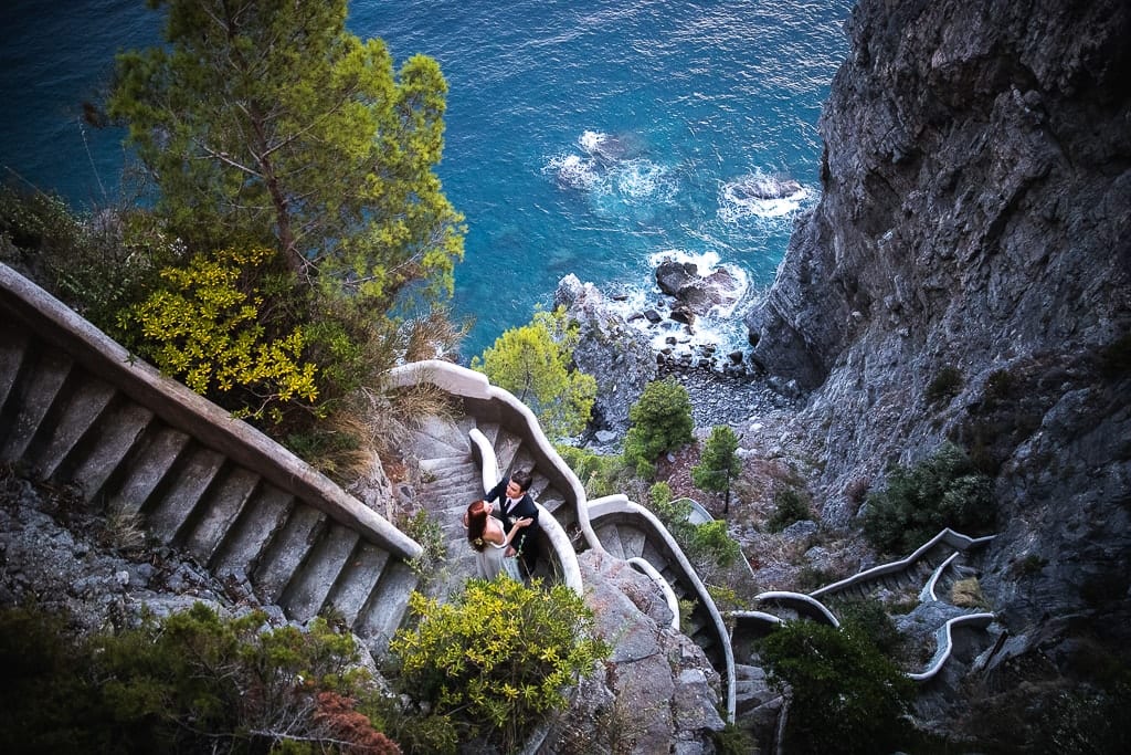 wedding couple on the stairs on a cliff in praiano in amalfi coast