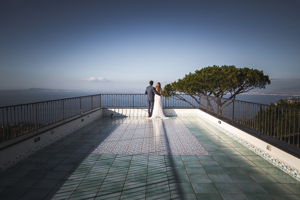 wedding couple from behind on a terrace in amalfi coast overlooking the sea