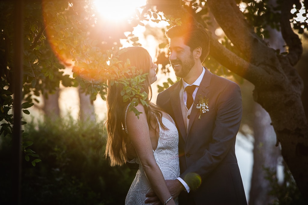 a wedding couple against the sun at sunset and lens flare