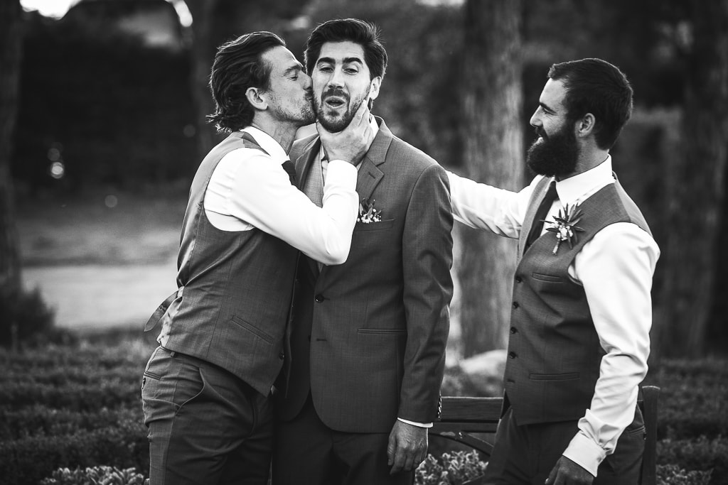 groom's best man kissing the groom