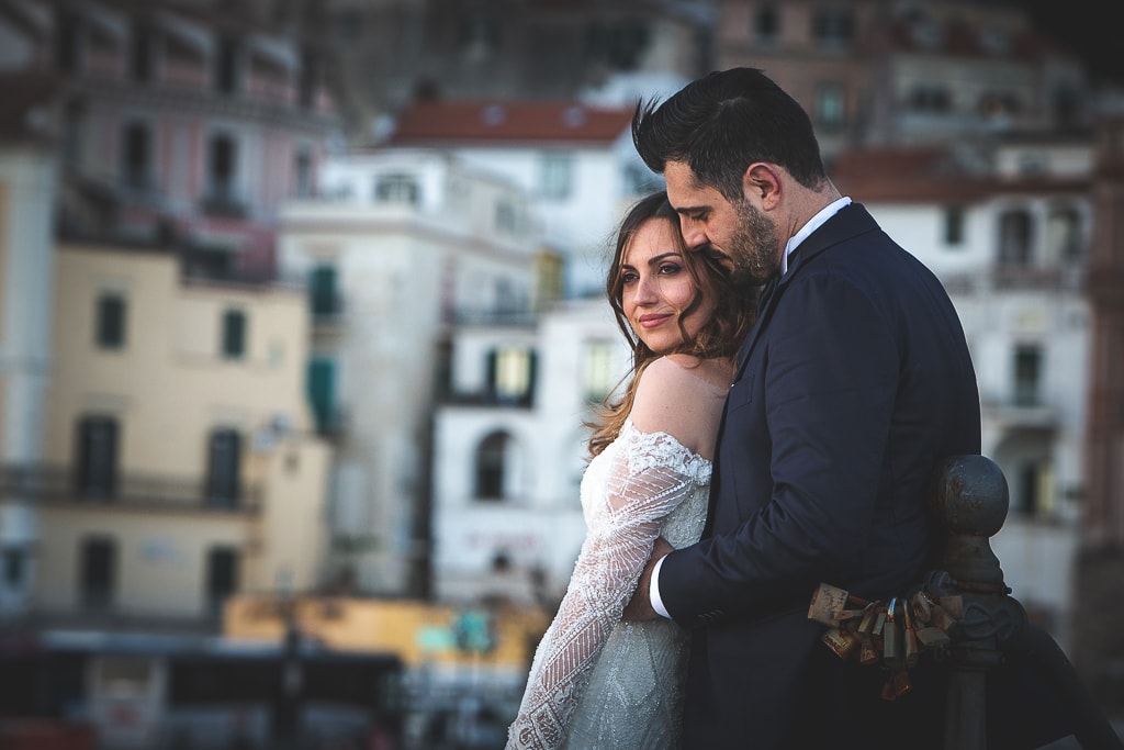 a wedding couple and amalfi town in the background
