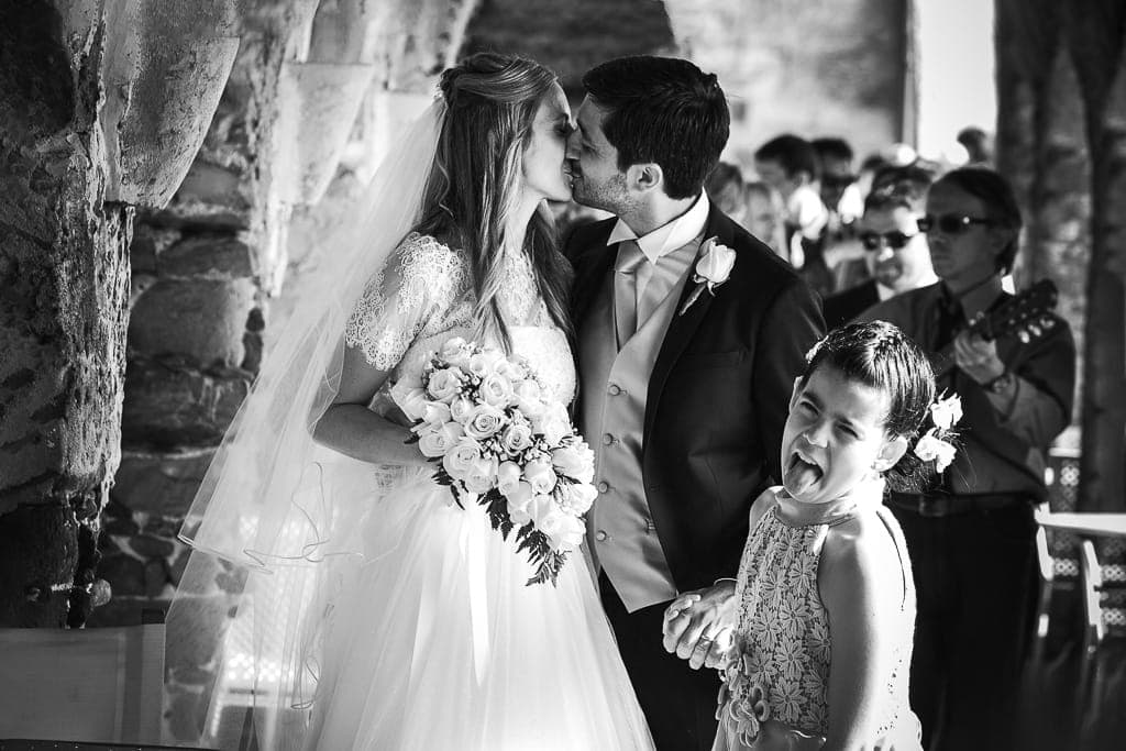 a flower girl shows her dislike for a wedding couple kissing