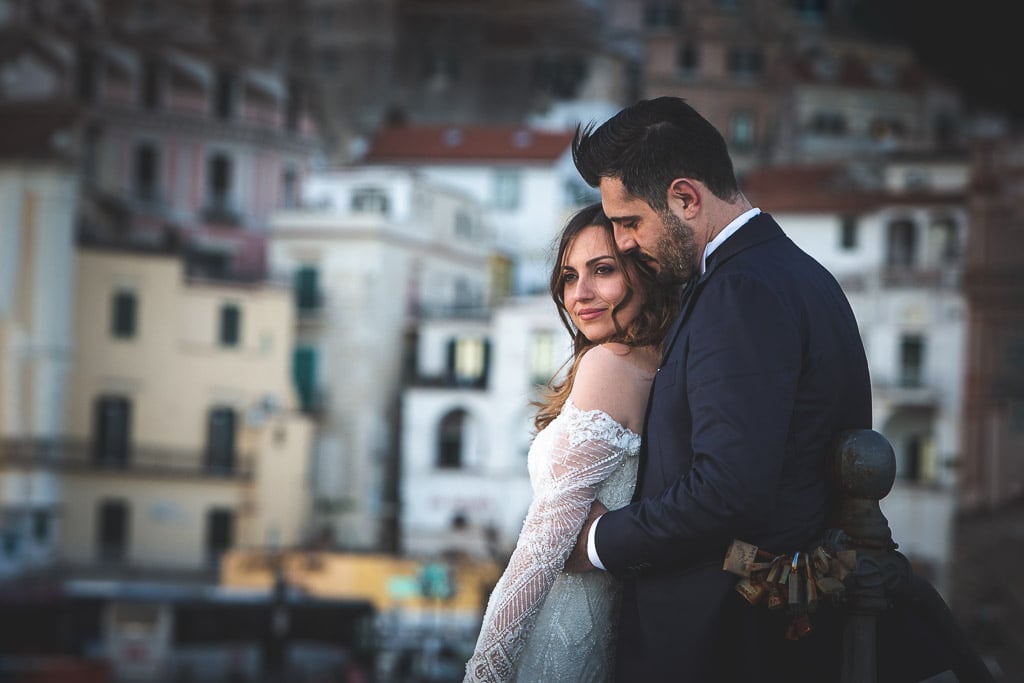 bride and groom portrait with a blurred background of amalfi town