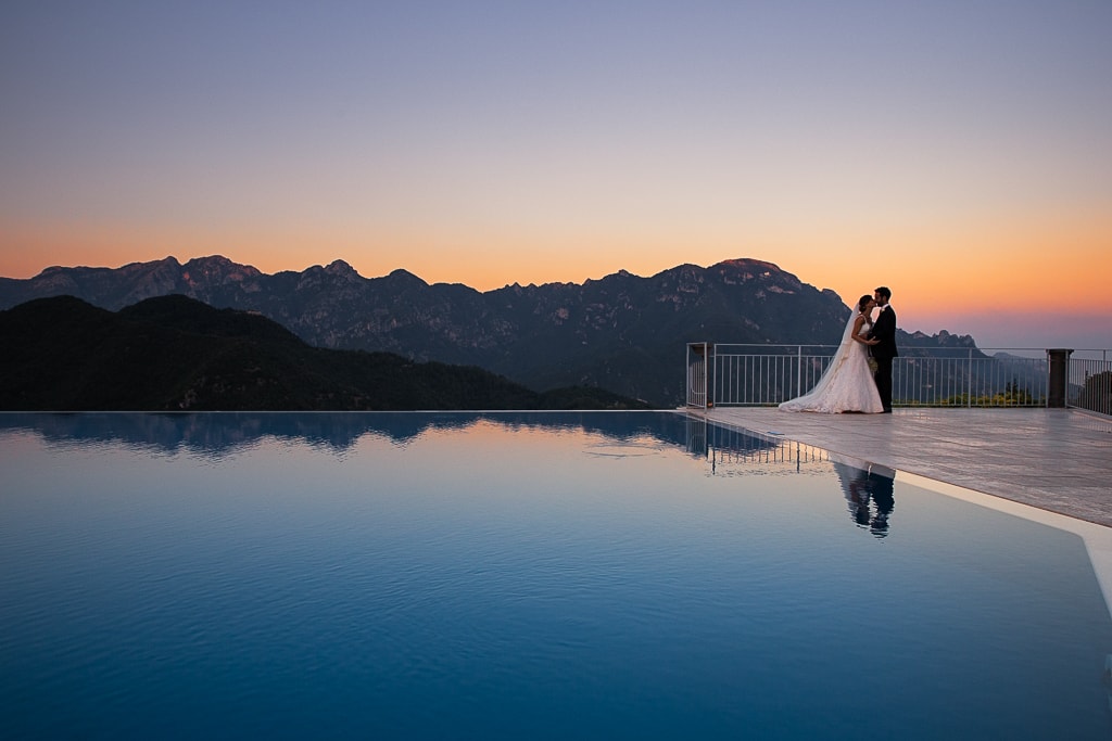 reflection of a wedding couple by the infinite pool at ravello hotel caruso in amalfi coast