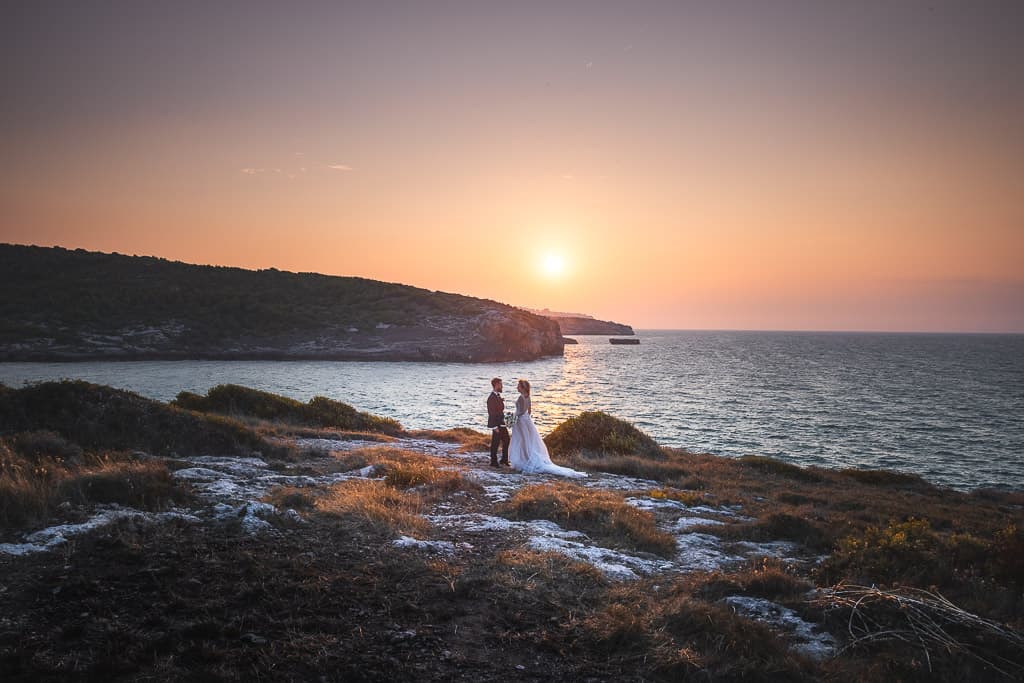 seascape at sunset on the coast in apulia and a wedding couple