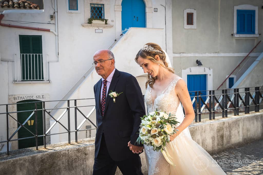 sposa e padre camminano verso la chiesa per celebrare un matrimonio in puglia