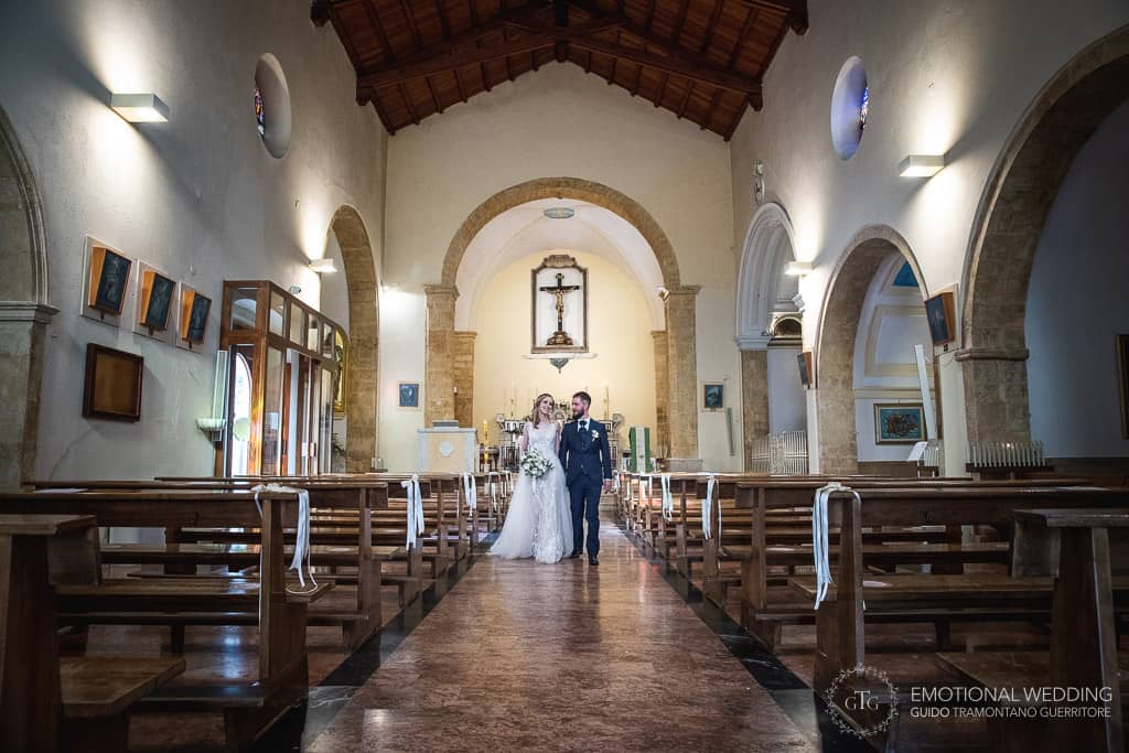 sposi escono dalla chiesa dopo la cerimonia di un matrimonio in puglia