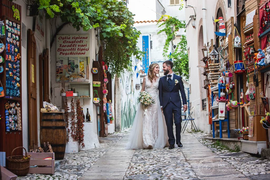 sposi passeggiano nel centro storico di peschici a un matrimonio in puglia