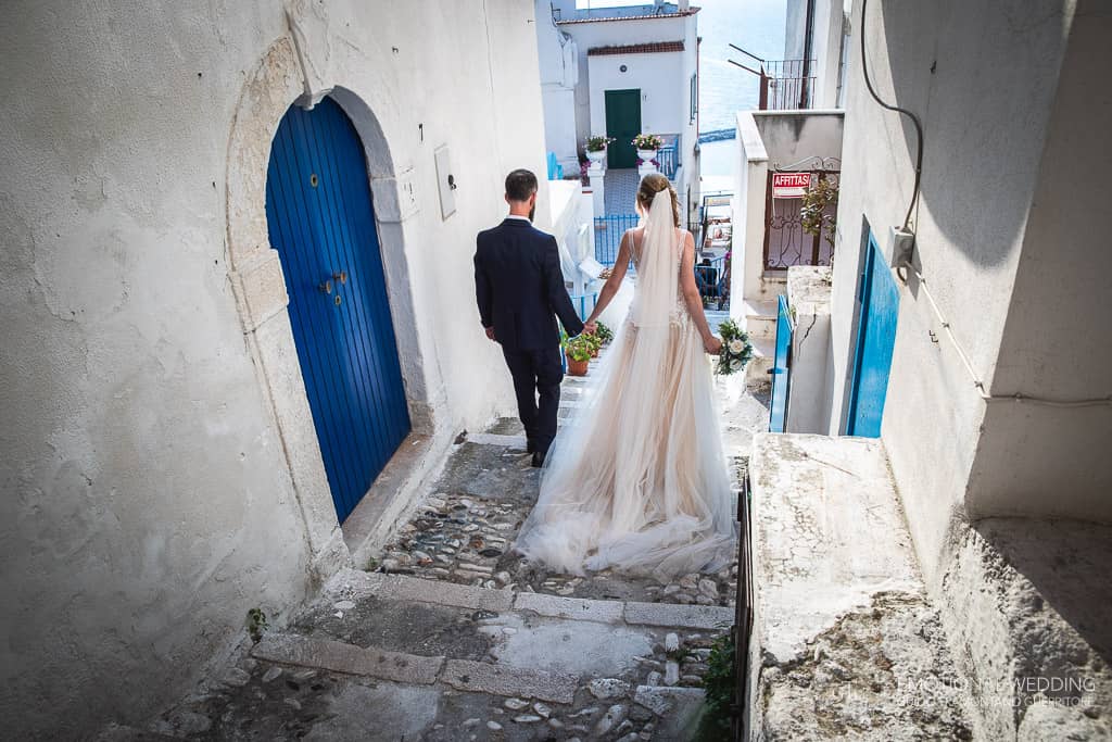 sposi passeggiano nei vicoli colorati di peschici a un matrimonio in puglia