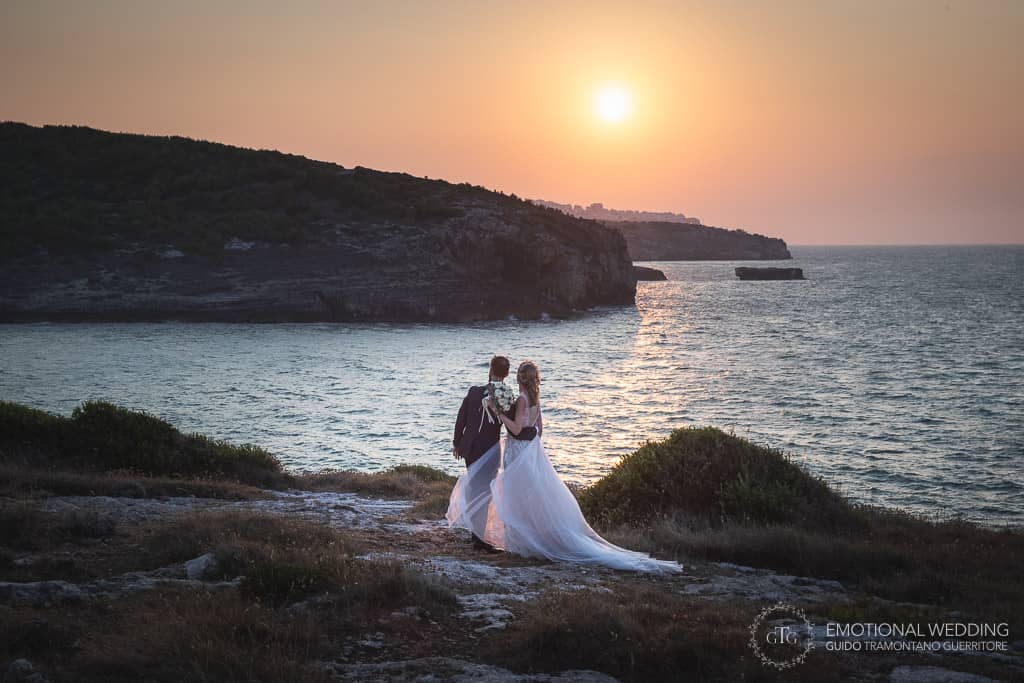 sposi ammirano il tramonto a un matrimonio in puglia