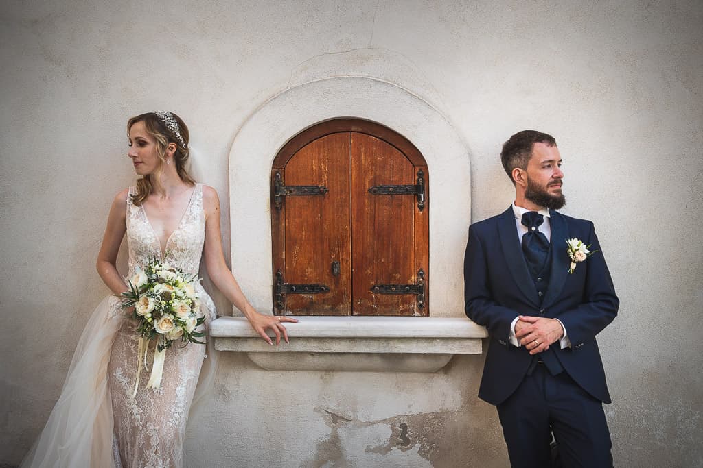 portrait of wedding couple looking in opposite directions in a typical Apulia town