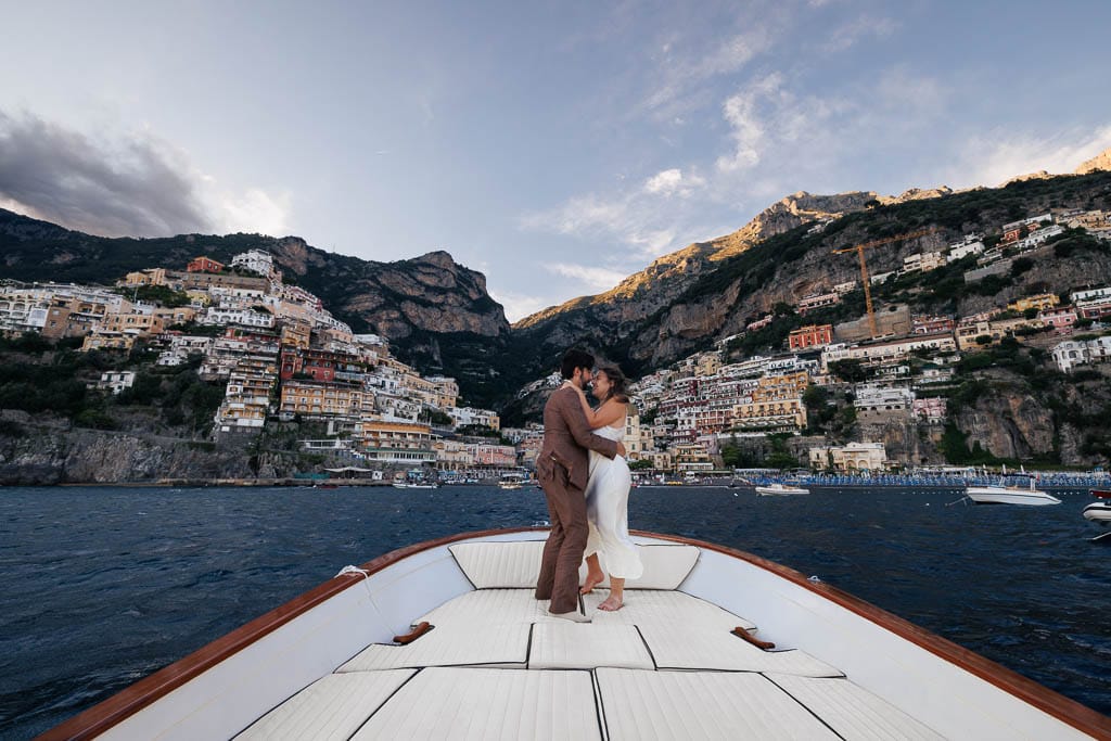 wedding couple on a boat and positano in the background