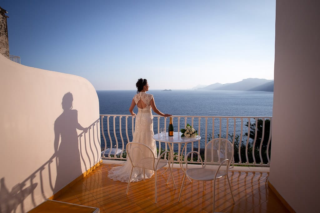 bride enjoying the view from a balcony at hotel tramonto d'oro in praiano amalfi coast