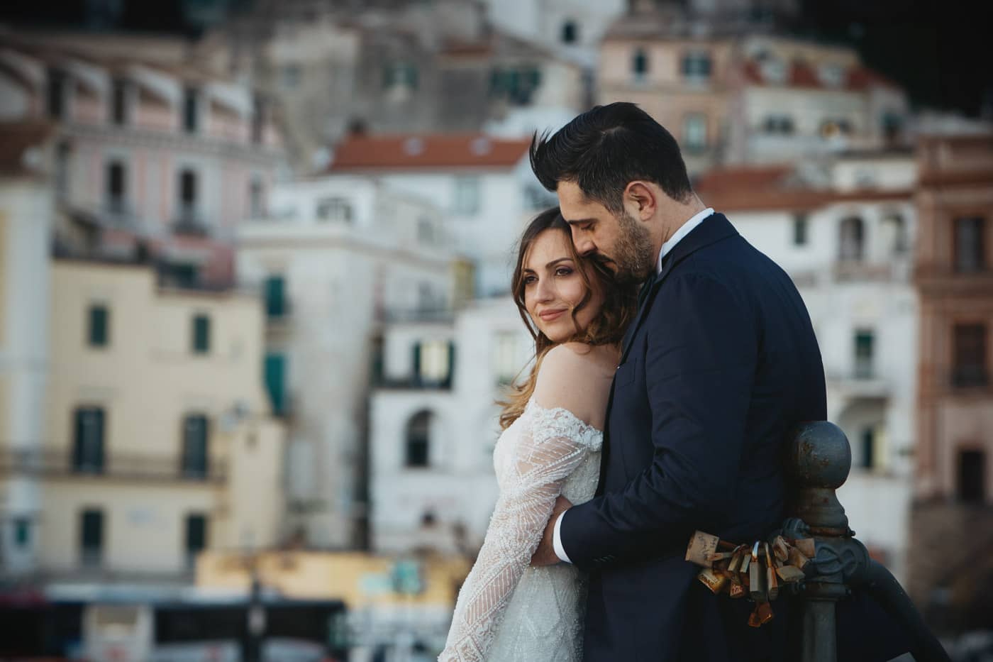 Intimate portrait of a romantic bride and groom with the iconic Amalfi Coast blurred in the background.