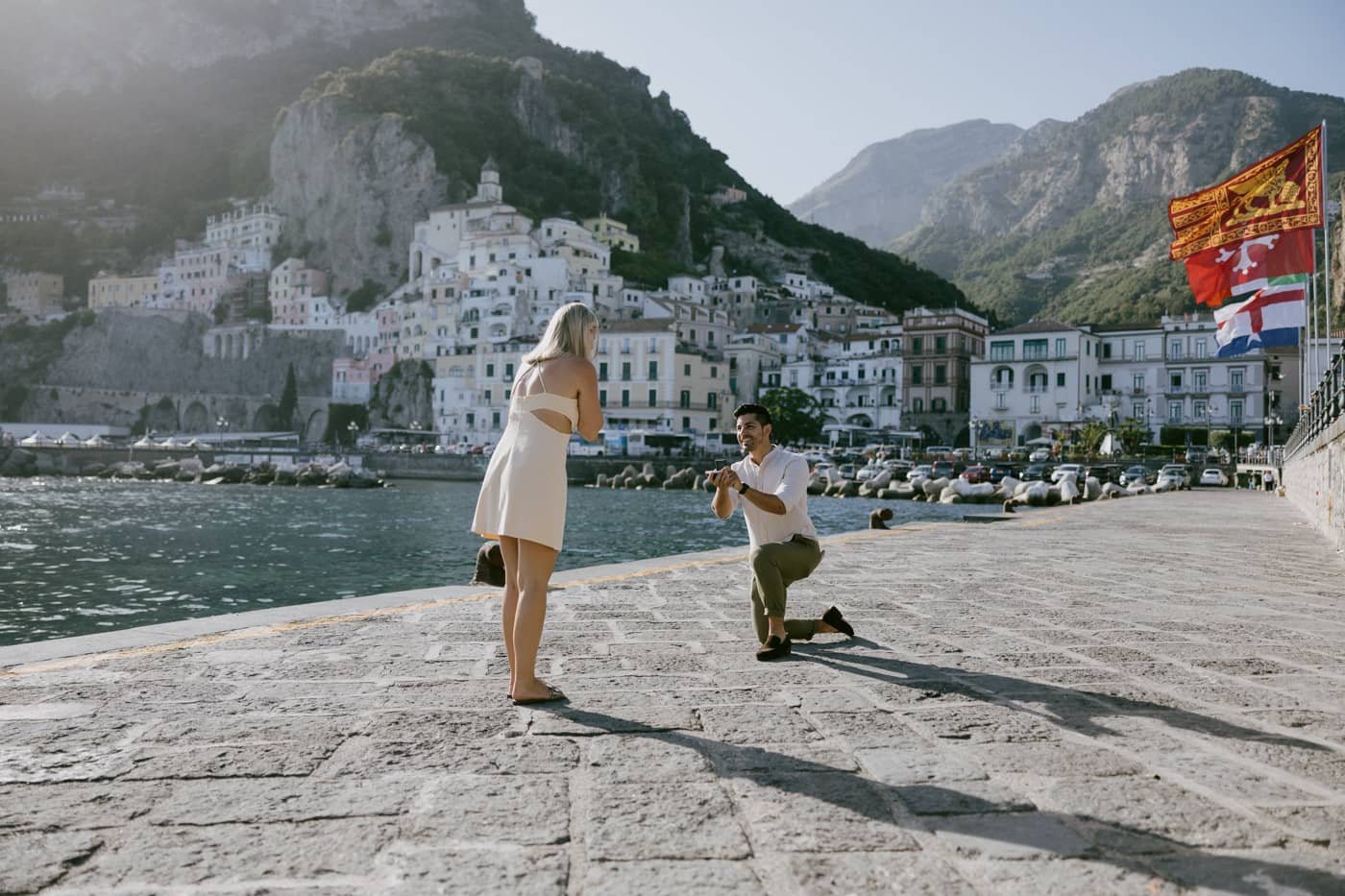 Joyful moment of a couple celebrating their engagement on the Amalfi Pier.