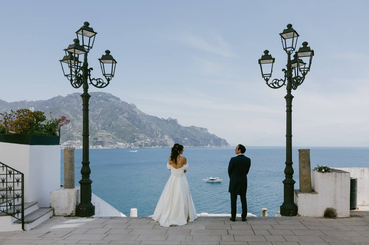Bride and groom on a terrace in Atrani overlooking the Mediterranean sea.