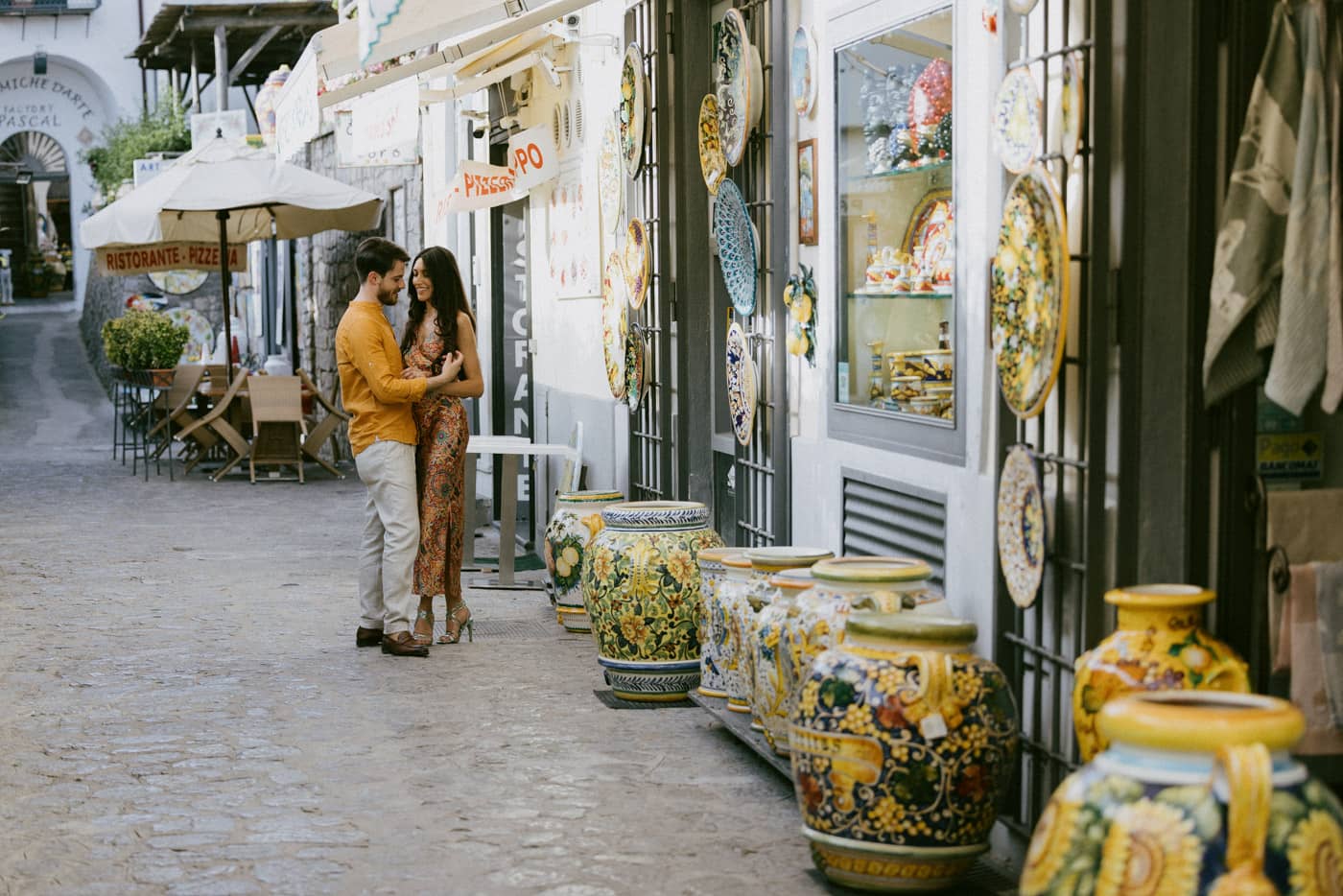 Romantic engagement couple standing in a traditional colorful alley — Engagement photography in Ravello, Amalfi Coast.