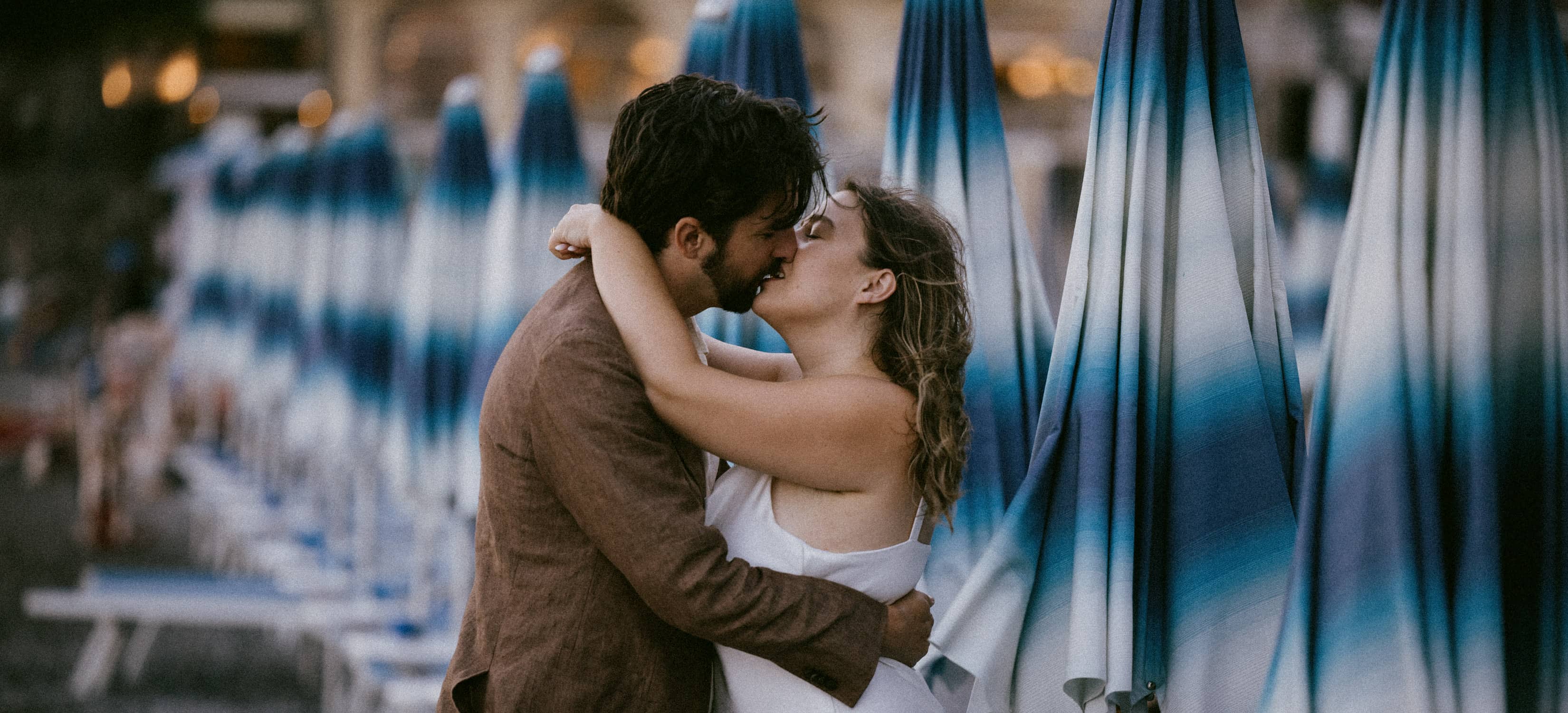 romantic moment of a wedding couple kissing at spiaggia grande in positano