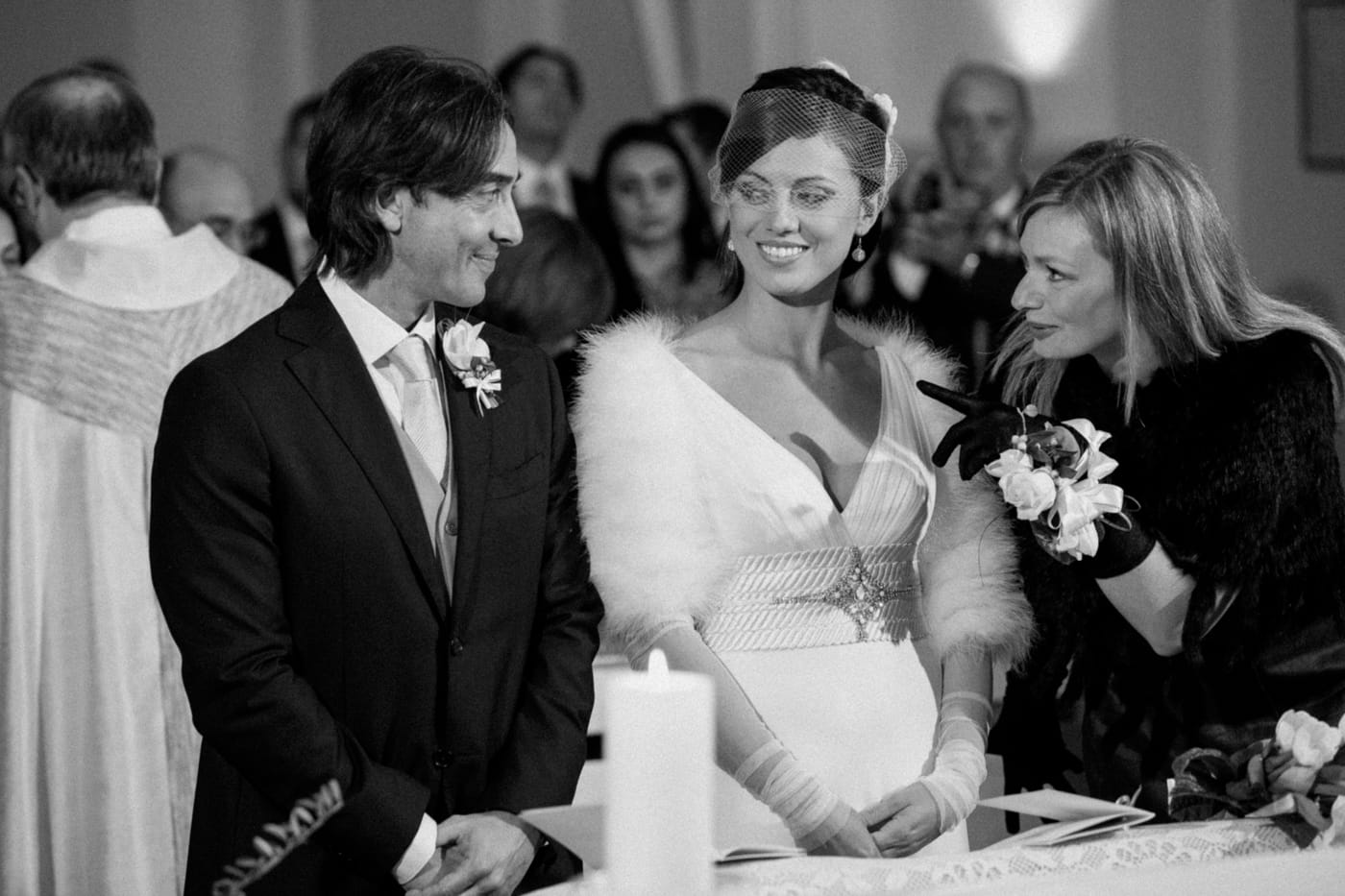 Black-and-white edit of the same candid ceremony moment, emulating Agfa Scala with refined tonal range, smooth gradations, and a clean, elegant monochrome aesthetic that highlights the emotion of the exchange.