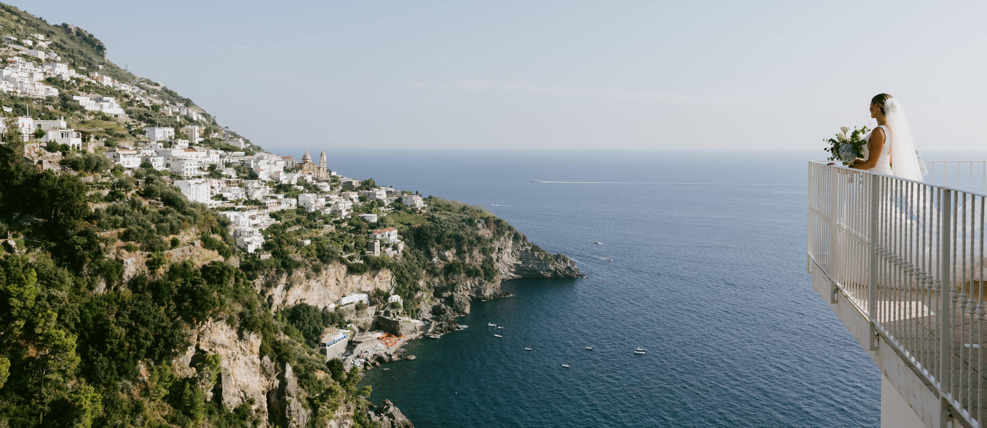Bride on a coastal terrace overlooking Praiano and the Mediterranean Sea — Amalfi Coast wedding photographer.