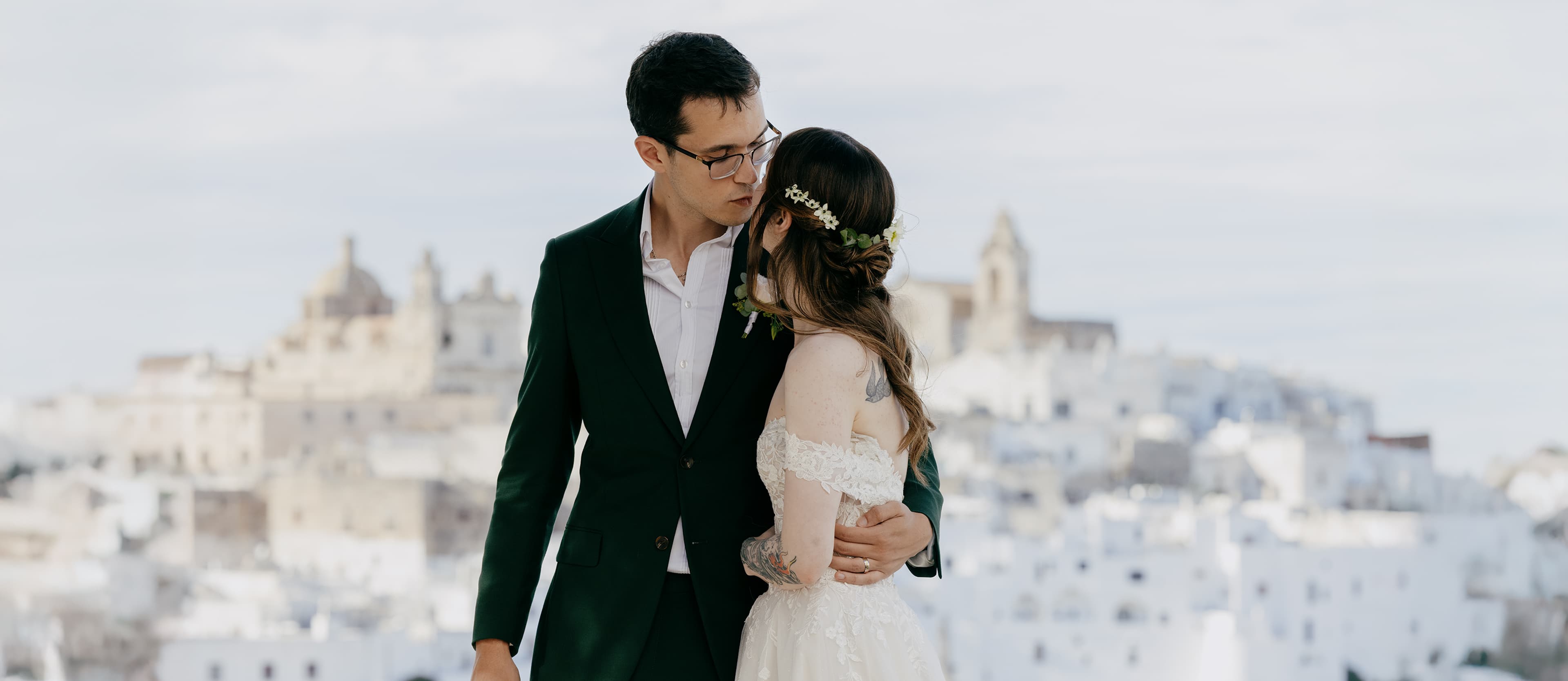 Intimate couple portrait with Ostuni's white architecture in the background — Ostuni Puglia wedding photography.
