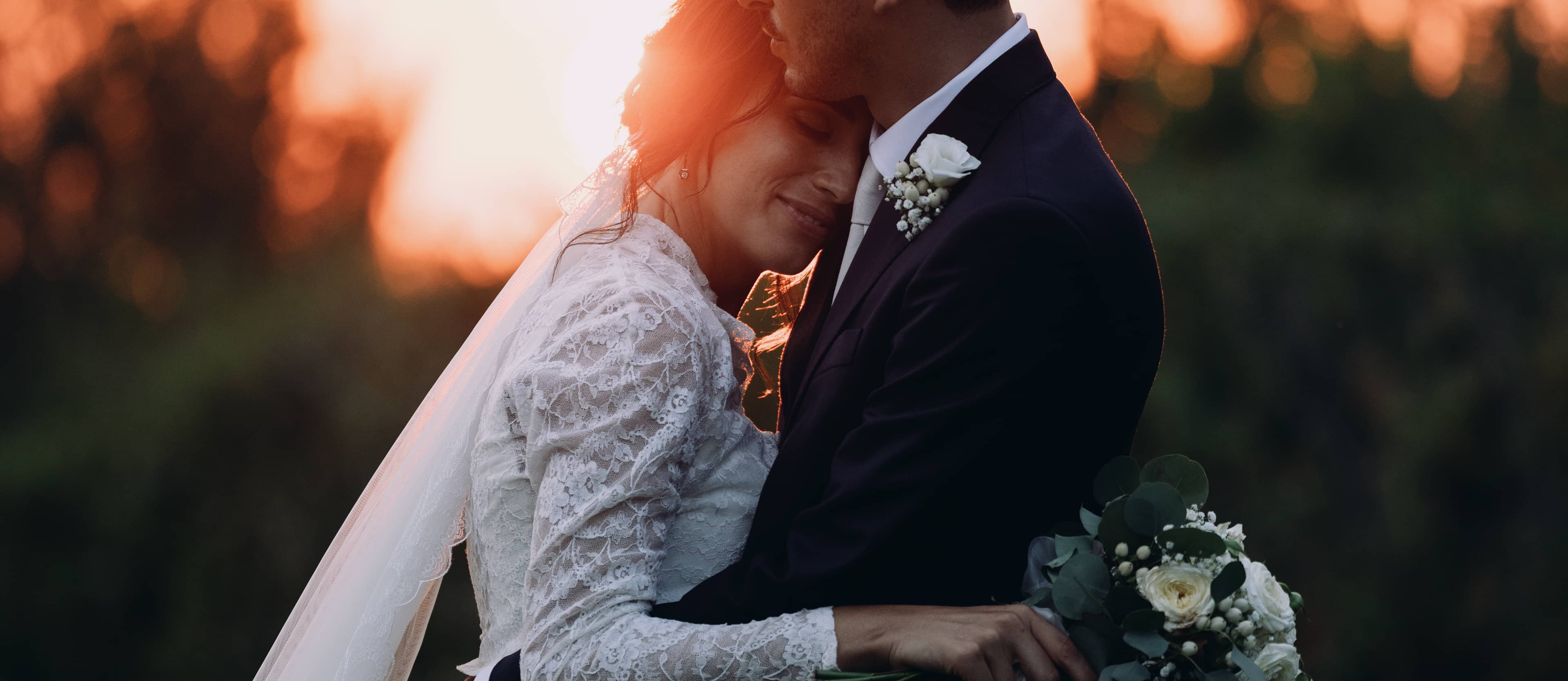 Romantic bride resting her head on the groom's chest at a Tuscan sunset — Tuscany destination wedding photography.